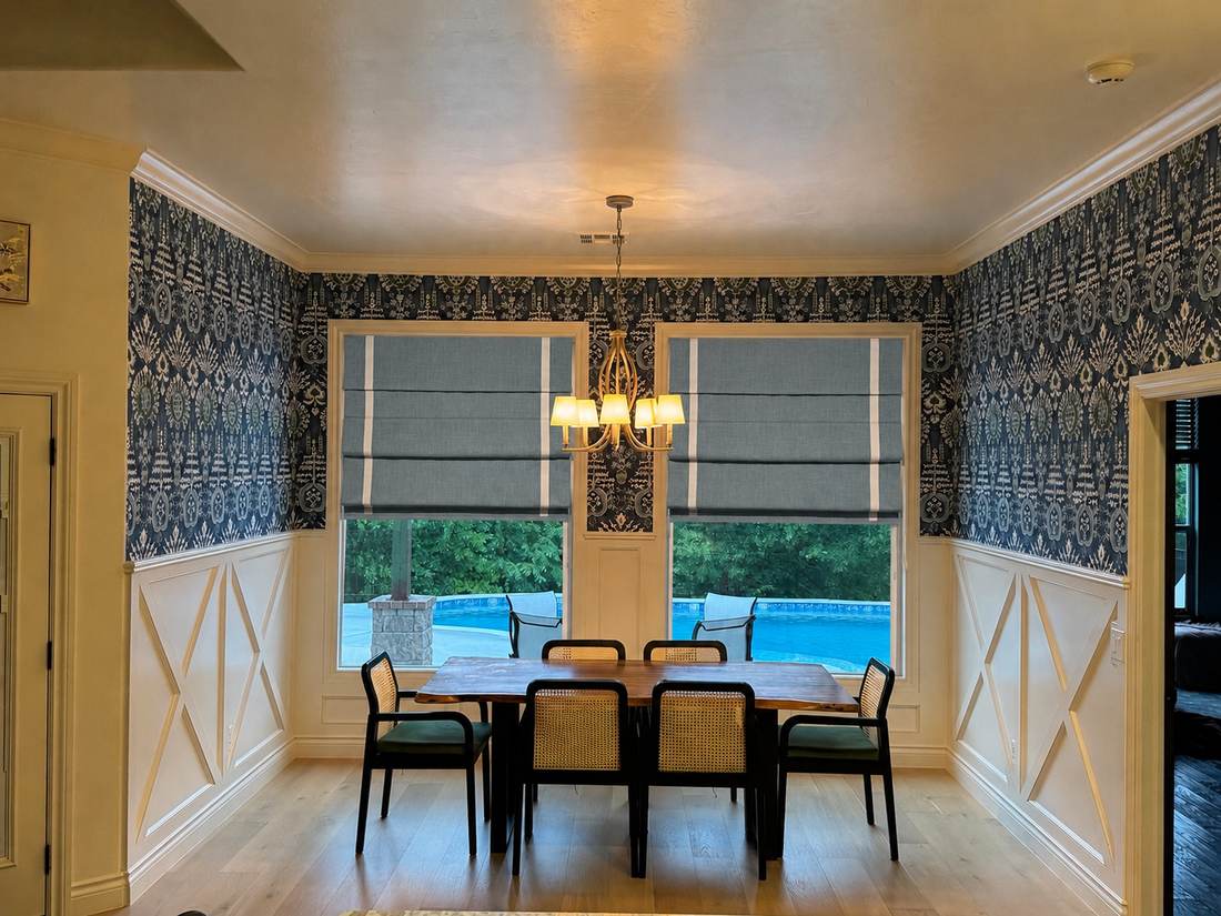 Roman shades with contrast banding over two dining room windows